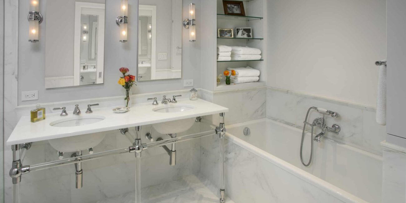 Double vanity marble bathroom NYC with polished fixtures by Gurri Remodel