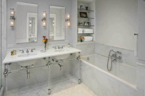 Double vanity marble bathroom NYC with polished fixtures by Gurri Remodel